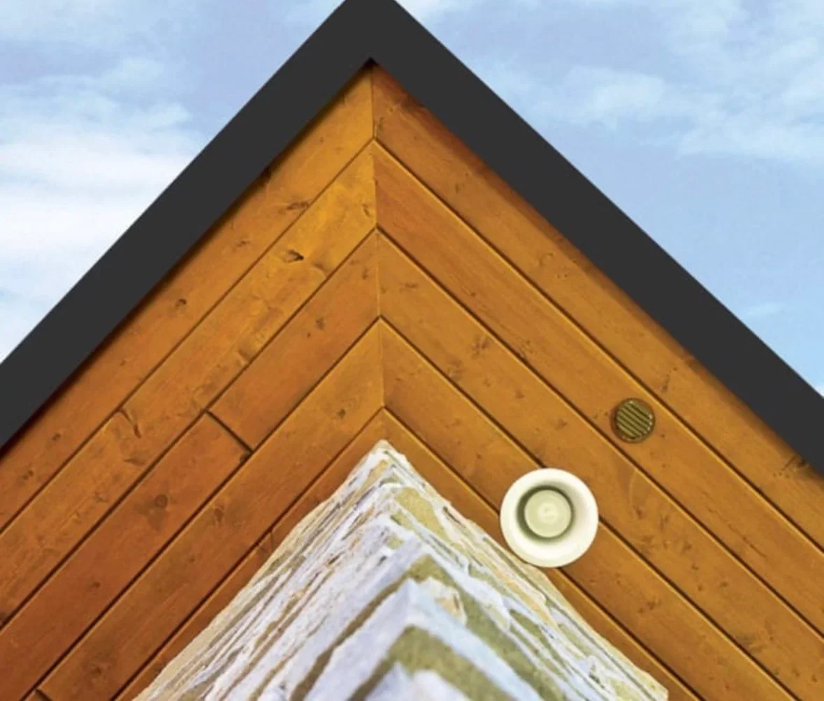 Cedar wood gable with herringbone pattern, black fascia trim, and soffit vents