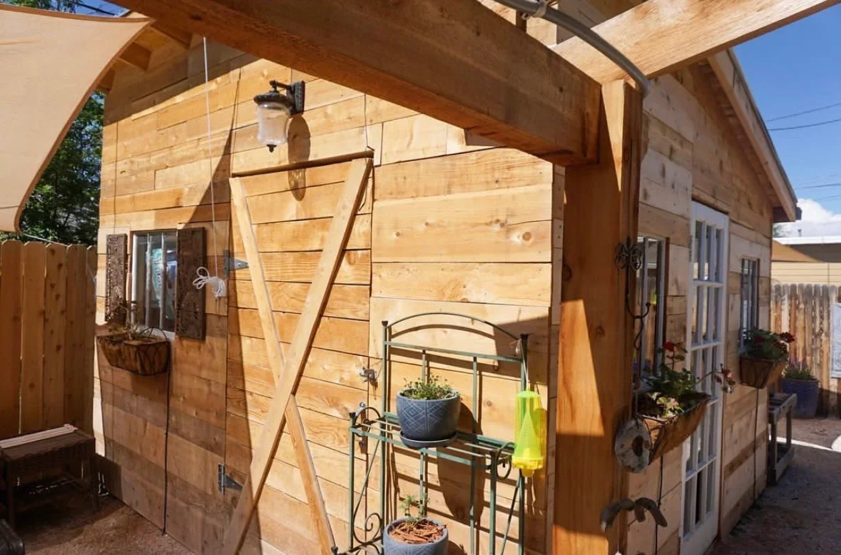 Cedar pergola with horizontal beams, sliding barn door, and wood siding construction