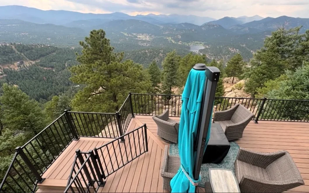 Composite deck with metal railing, lounge seating, and retractable shade on mountain overlook