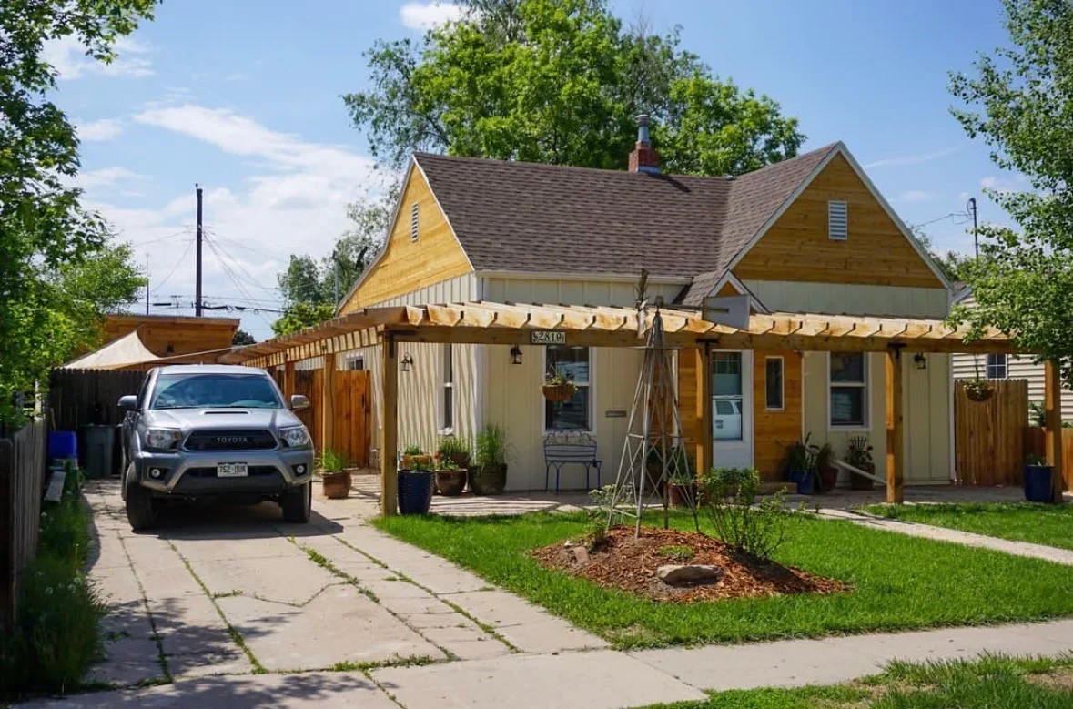 Wood deck and covered porch with canvas awning, planter boxes, and concrete walkway