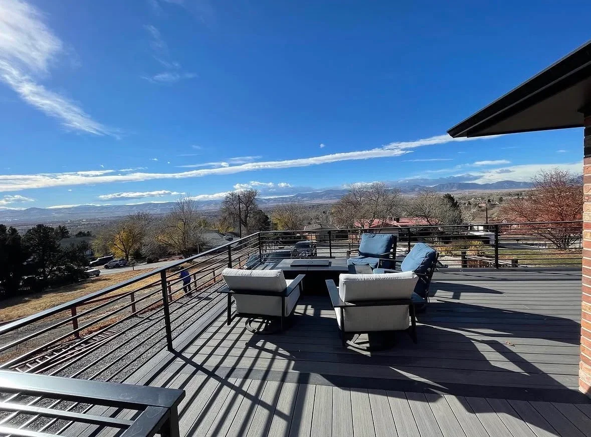 Composite deck with cable railings, pergola, and lounge seating overlooking valley landscape