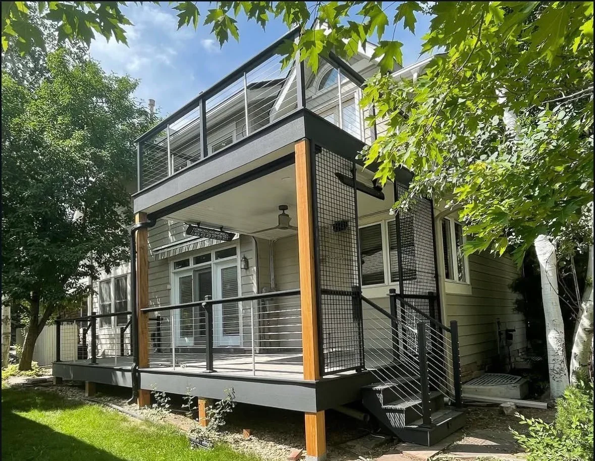 Two-story composite deck with cable railing, glass panels, and black aluminum frame