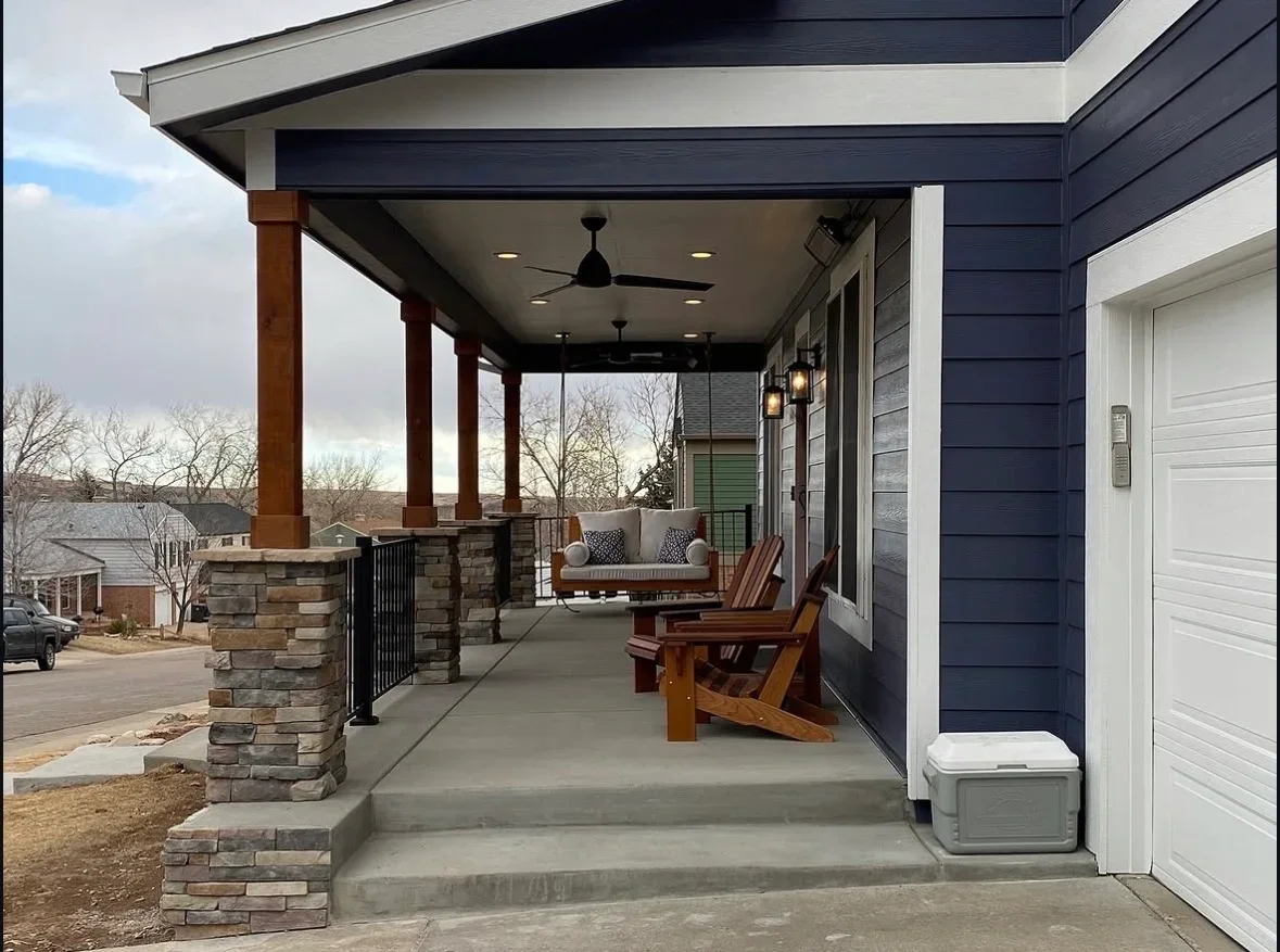 Covered patio with timber posts, stone pillars, concrete pad, and ceiling fans