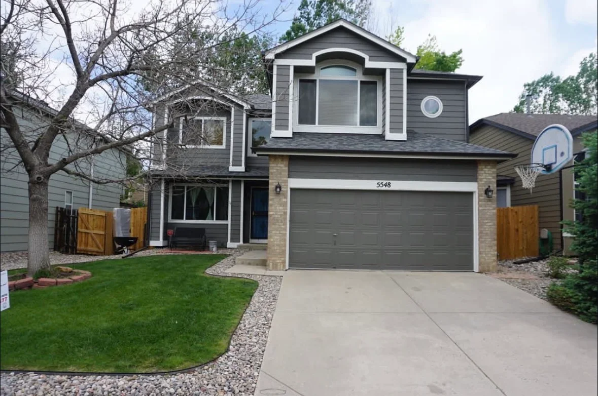 Concrete driveway with gravel borders and landscape edging in front of two-story home