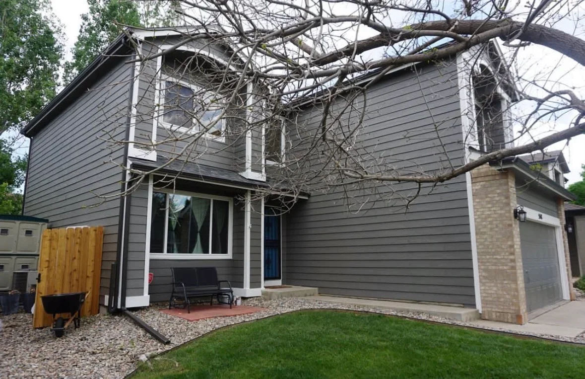 Gray fiber cement siding home with brick paver patio and gravel landscaping