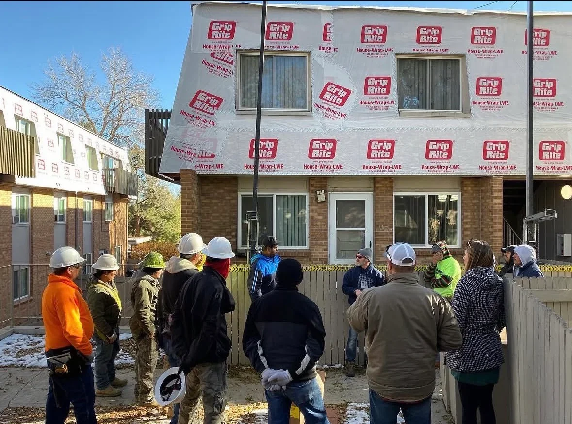 House wrap installation on two-story brick building with Grip-Rite House-Wrap LWE covering upper facade