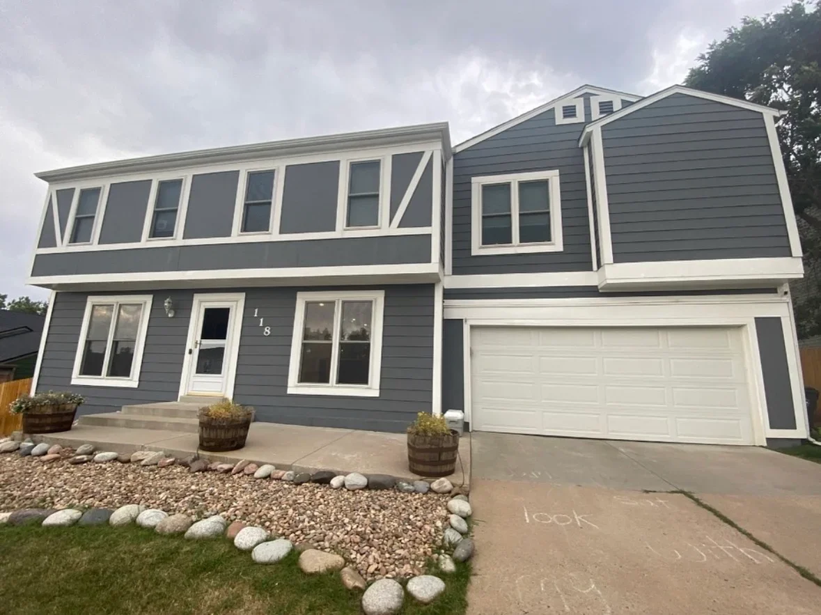 Modern two-story home with gray fiber cement siding, white trim, and concrete driveway