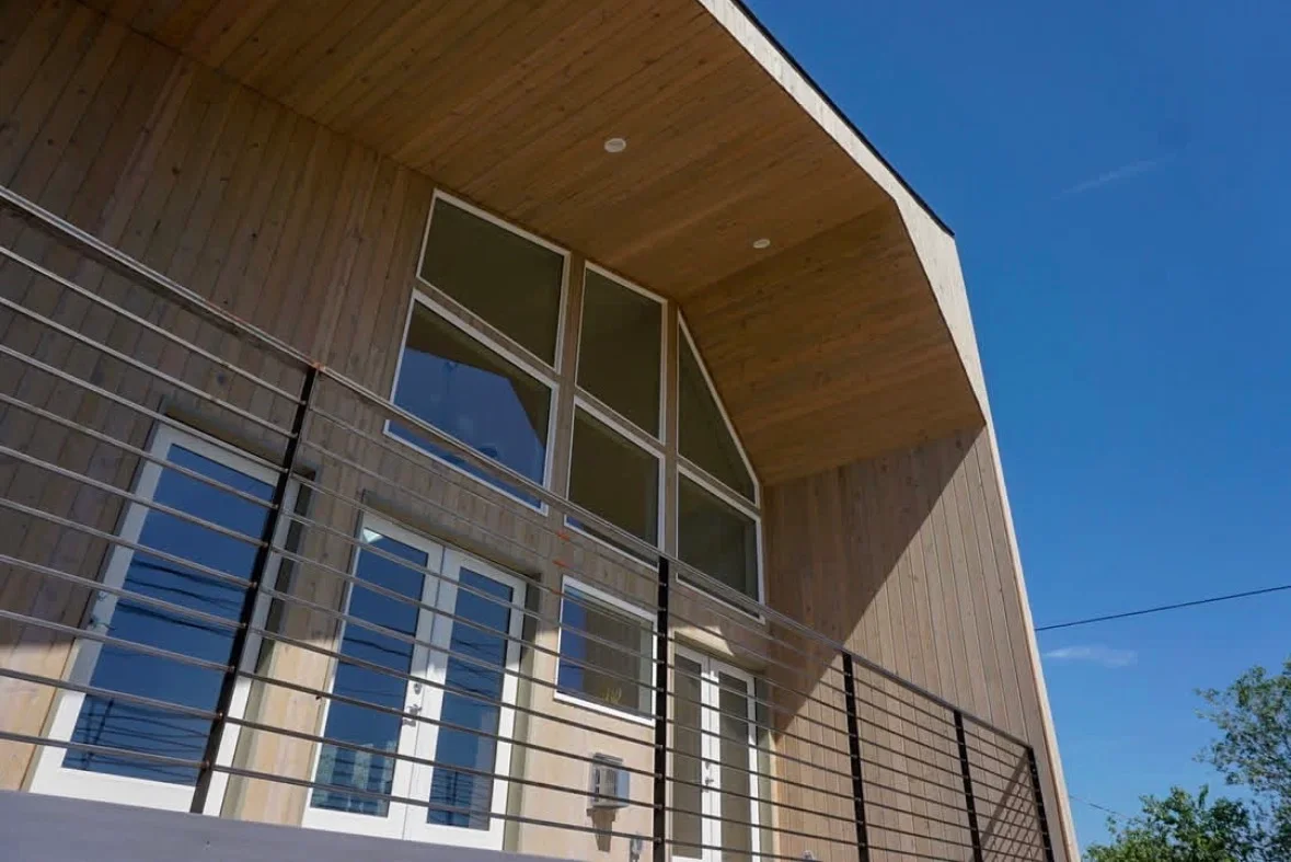 Elevated deck with horizontal cable railing, wood siding, and modern architectural details