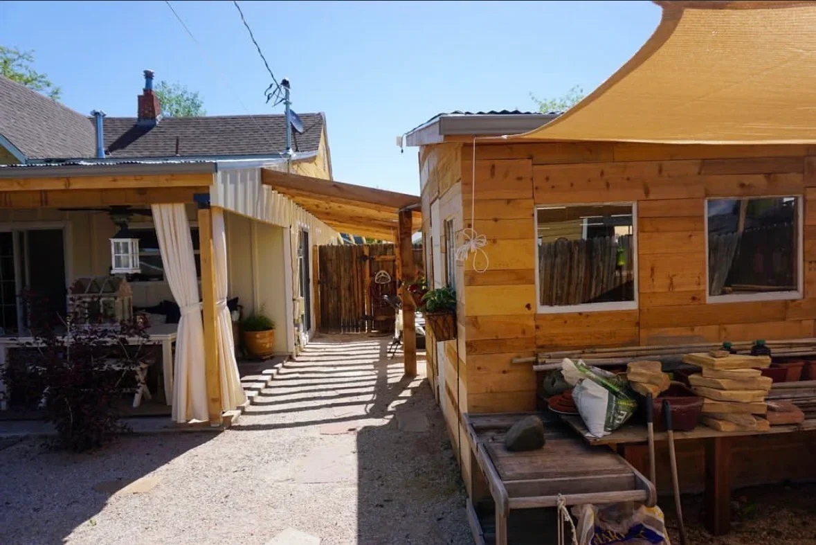 Cedar wood patio with shade sail, wooden framing, and gravel base