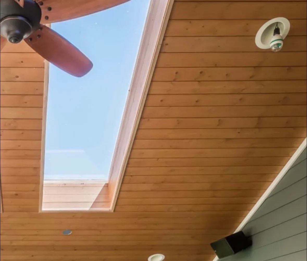 Cedar tongue-and-groove ceiling with skylight, recessed lighting, and white trim details