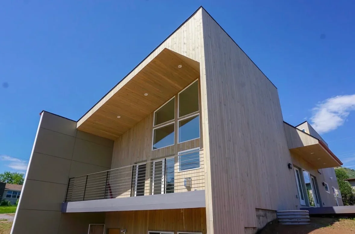 Elevated composite deck with metal cable railing and recessed lighting on modern home