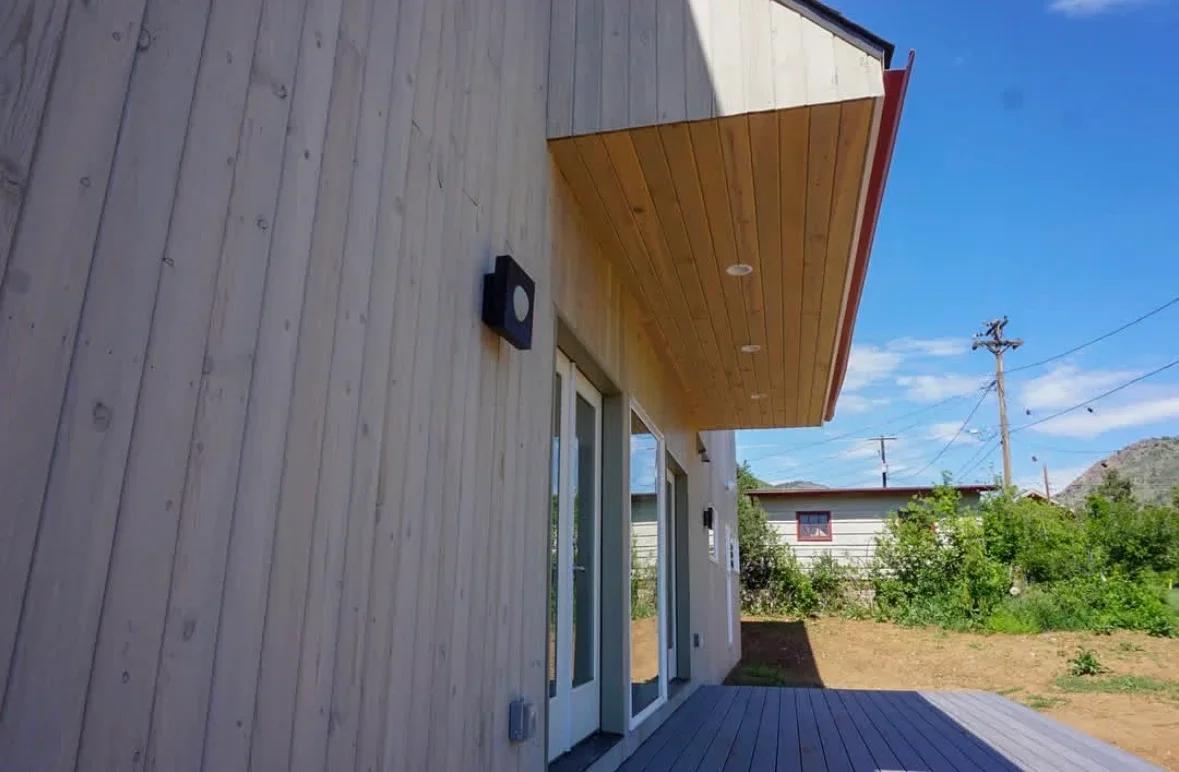 Composite deck with wood ceiling overhang, recessed lights, and metal siding