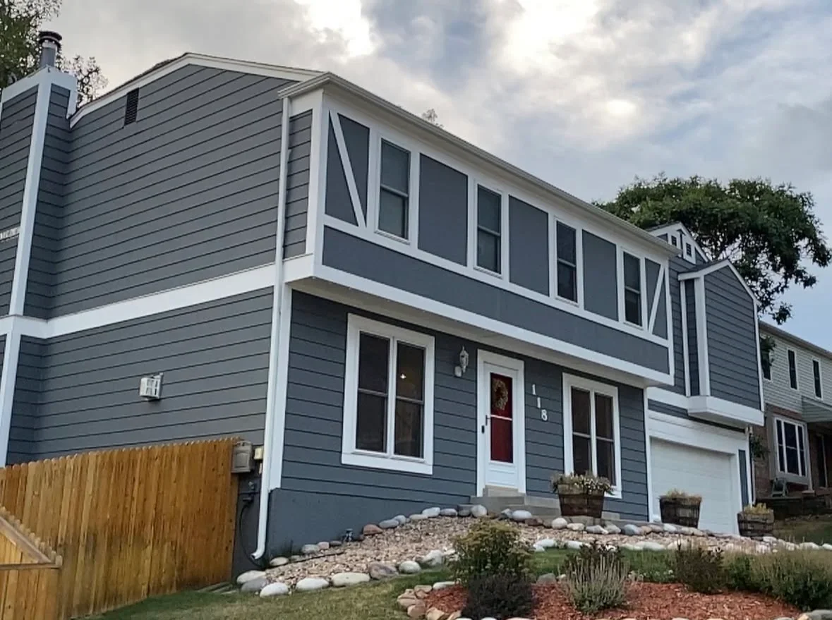 Two-story home with slate blue horizontal siding, white trim, and new window installation