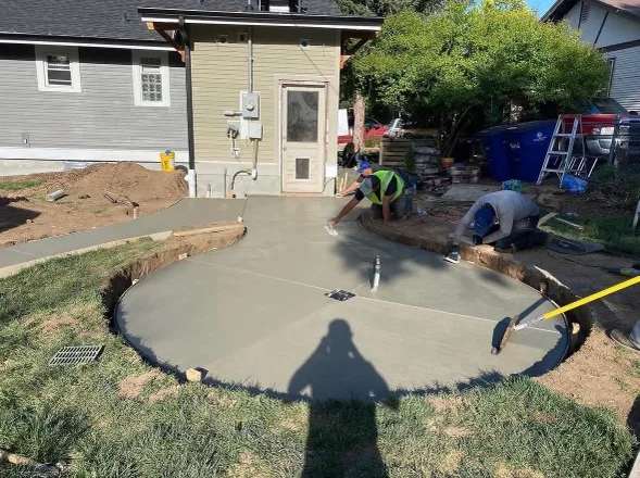 A freshly finished concrete driveway at a residential property in Littleton, Colorado, showing a clean broom texture and straight control joints. The surface runs from the garage apron to the street with no visible cracking or scaling.